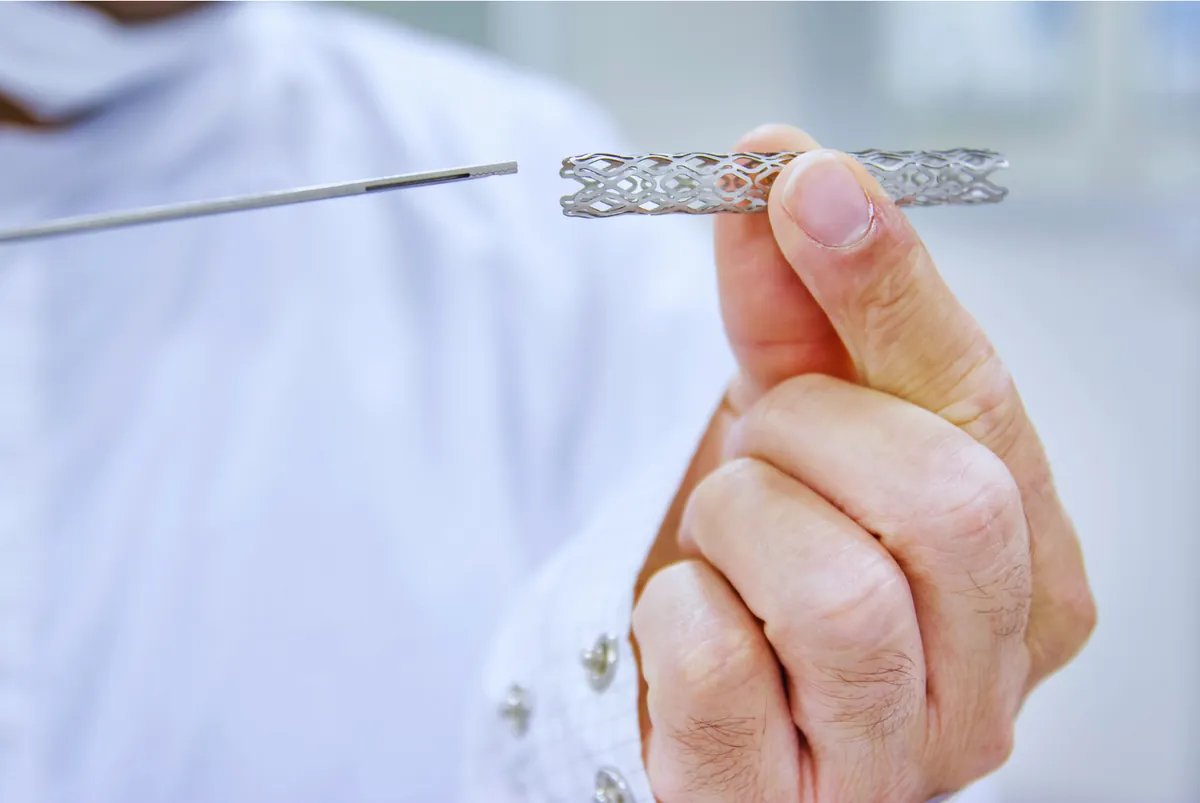 Stent coronario sostenido con una pinza durante un procedimiento de cateterismo cardíaco