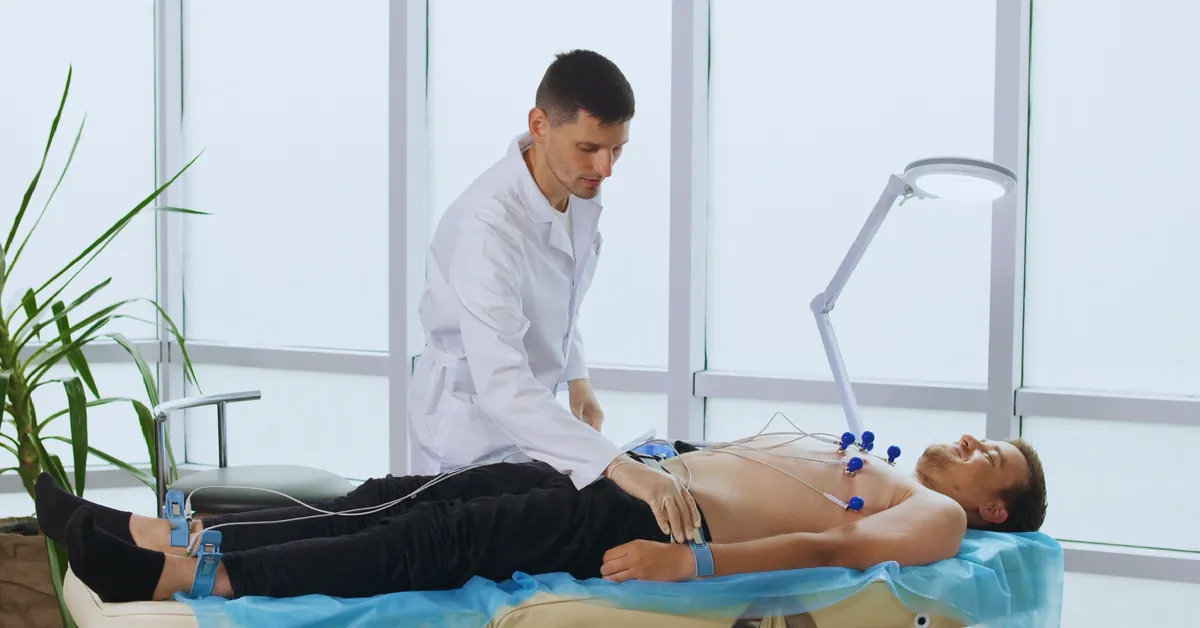 Paciente acostado con los electrodos colocados para un electrocardiograma