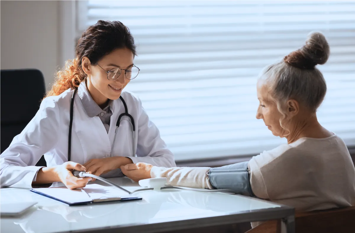 Cardióloga tomando la presión arterial a una paciente durante una evaluación vascular